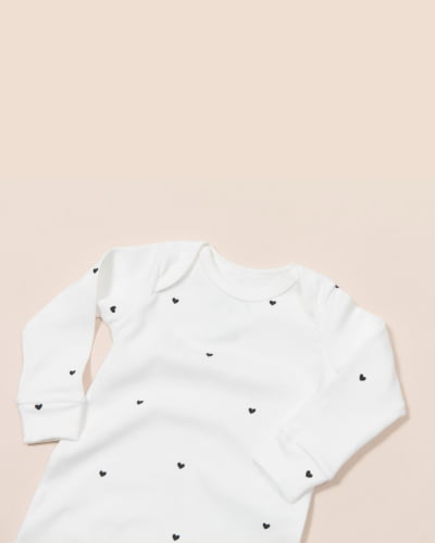 MACACÃO MANGA LONGA OFF WHITE COM ESTAMPA CORAÇÃO