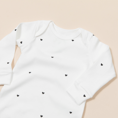 MACACÃO MANGA LONGA OFF WHITE COM ESTAMPA CORAÇÃO